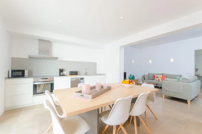 An open-plan kitchen and dining area with a table and seating.