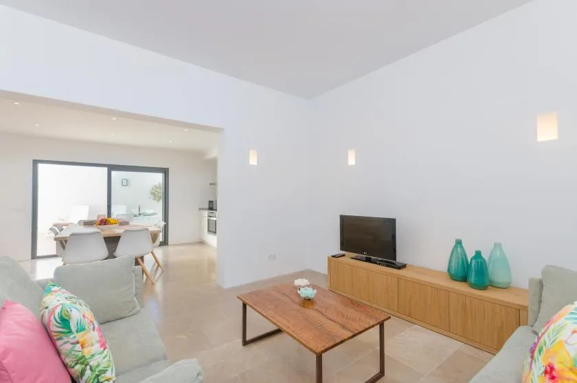A bright living room with a wooden coffee table and television.