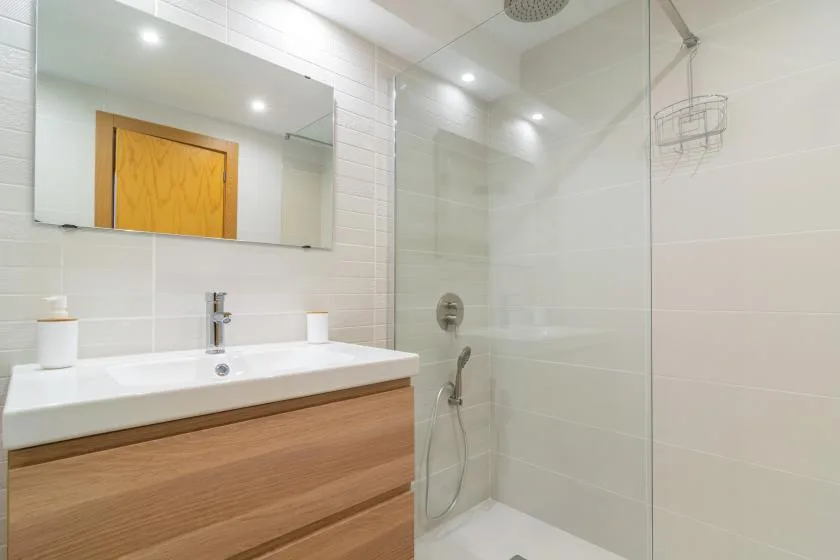 A bright bathroom with a wide vanity and glass shower.