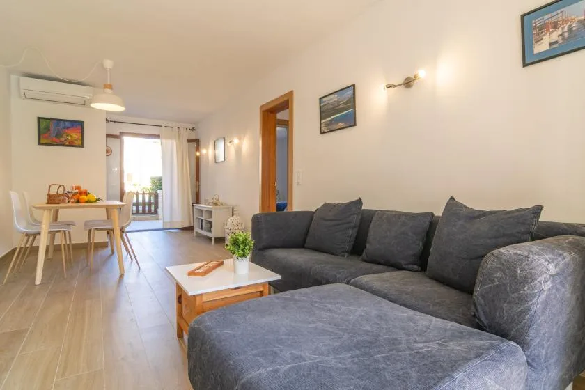 A living and dining area with a gray sectional sofa and a table by the window.