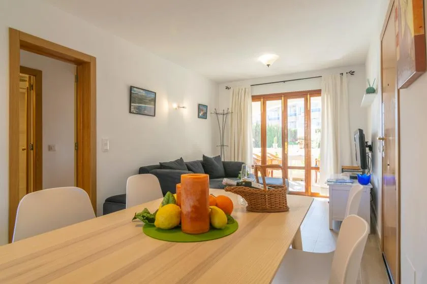 A dining area with a wooden table and seating beside a living room.