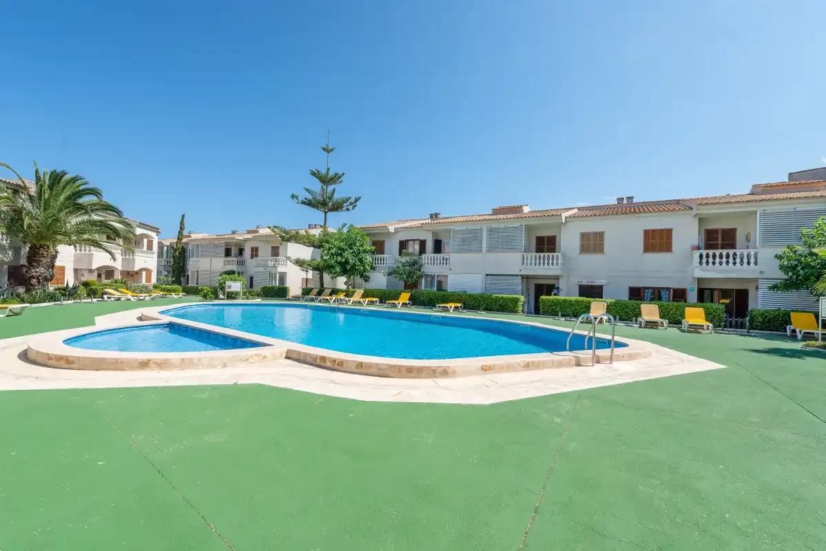 A swimming pool sits in a paved courtyard surrounded by residential buildings.