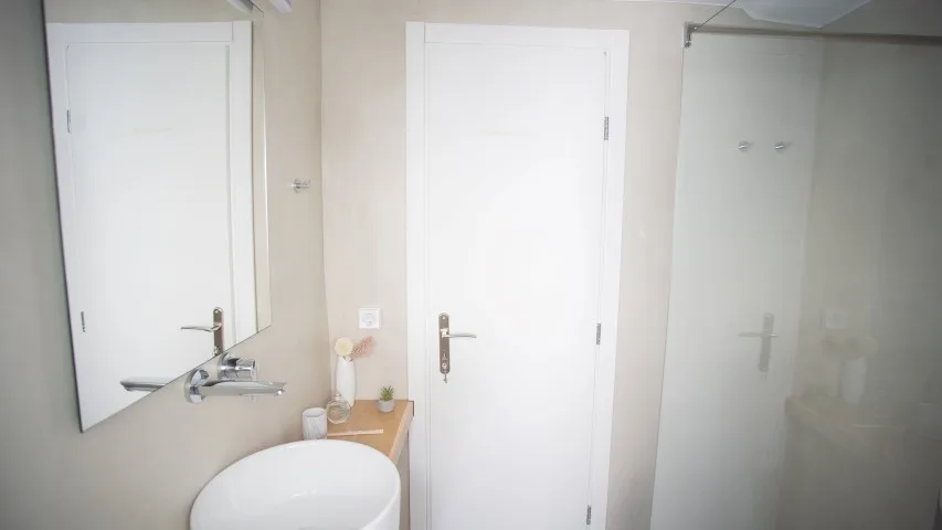 Un baño con lavabo, espejo y ducha.