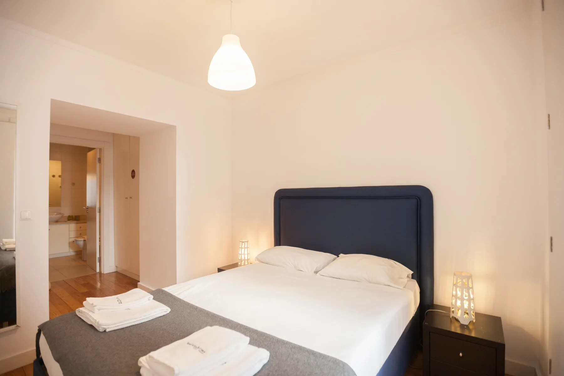 Dormitorio con una cama bien hecha y mesitas de noche.