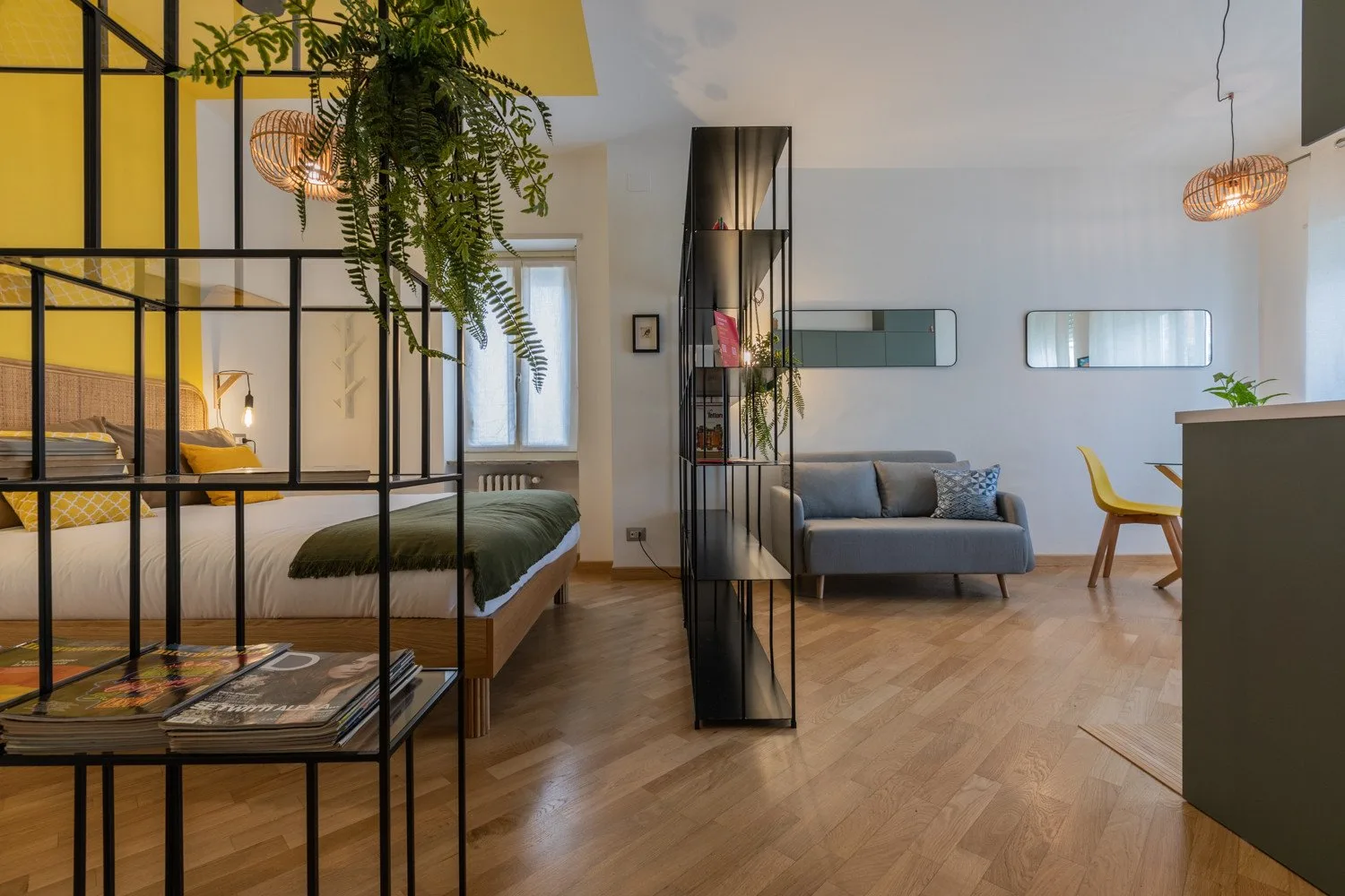 A modern living area with a bed, sofa, and dining table.