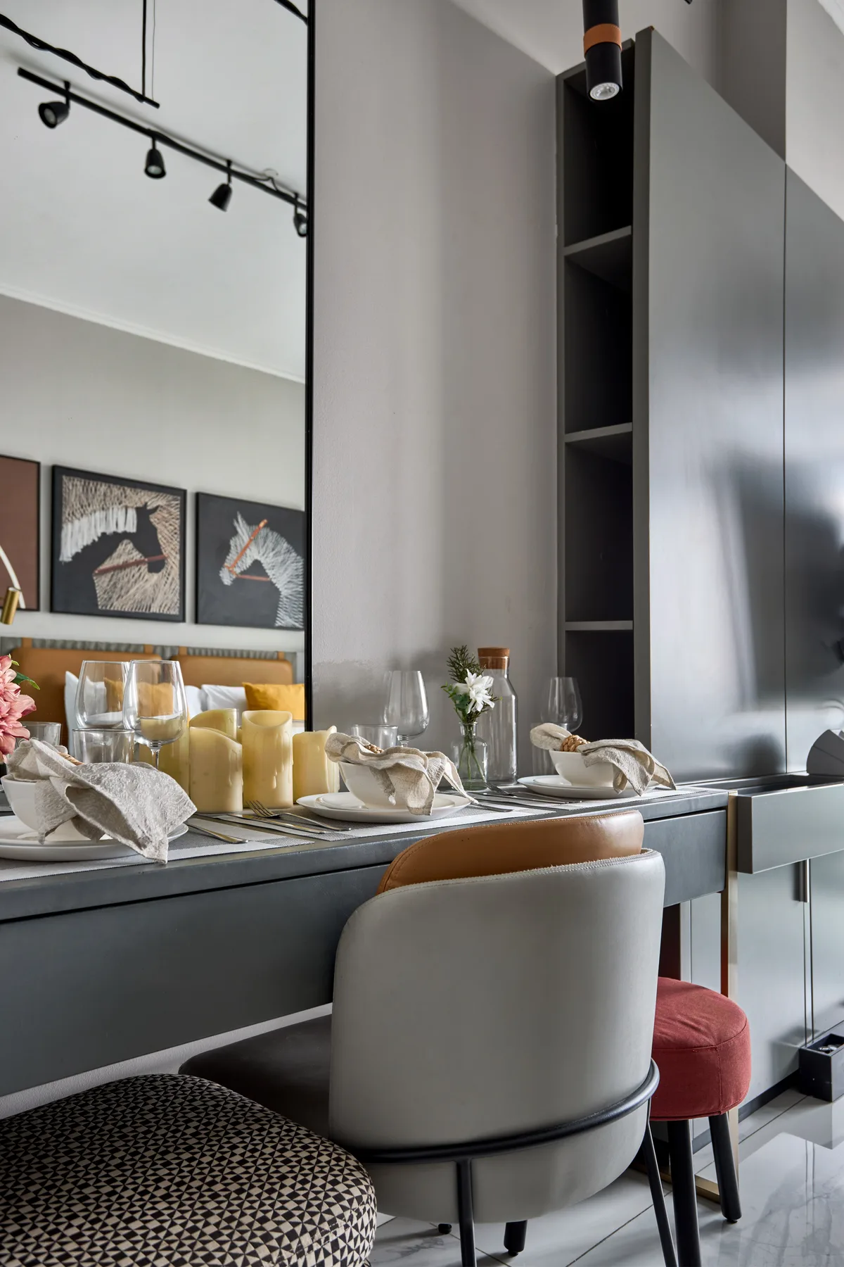 A dining area with a set table, upholstered seating, and framed artwork.