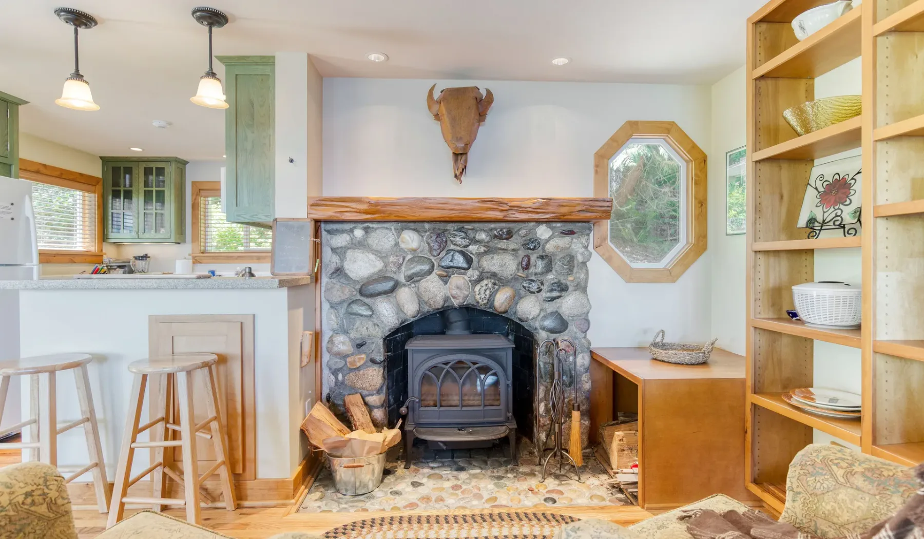 Una sala de estar con una chimenea de piedra y estanterías de madera.