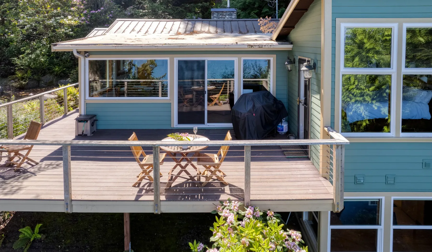 Una terraza exterior con una mesa de comedor y asientos junto a una casa.