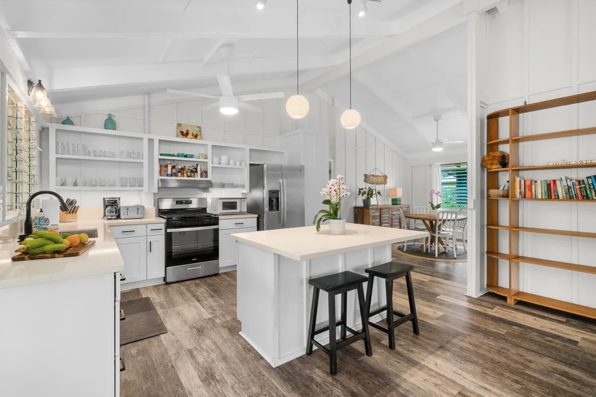 Una cocina luminosa con una isla central y estanterías abiertas.