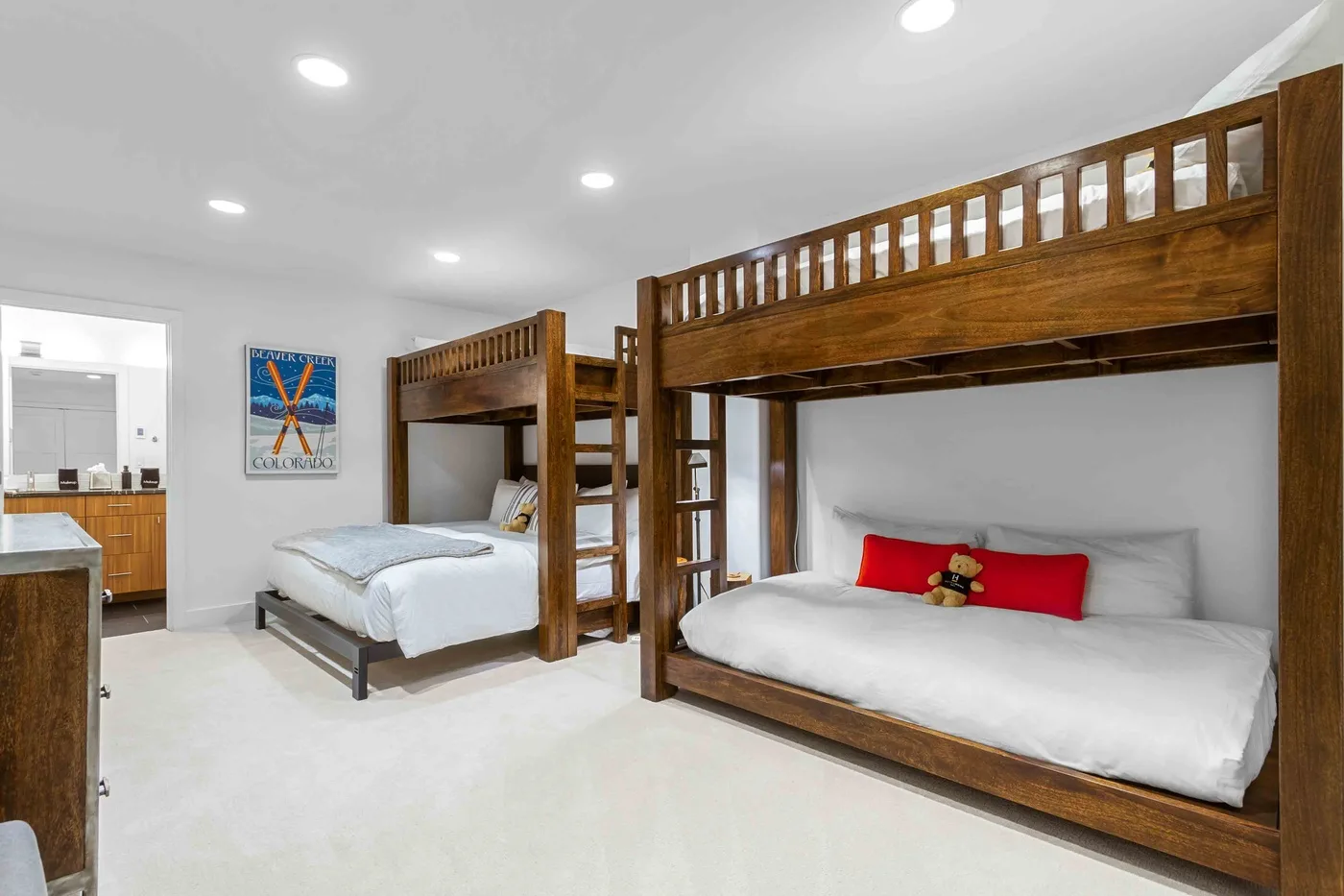 Un dormitorio con dos literas de madera y ropa de cama blanca bien arreglada.