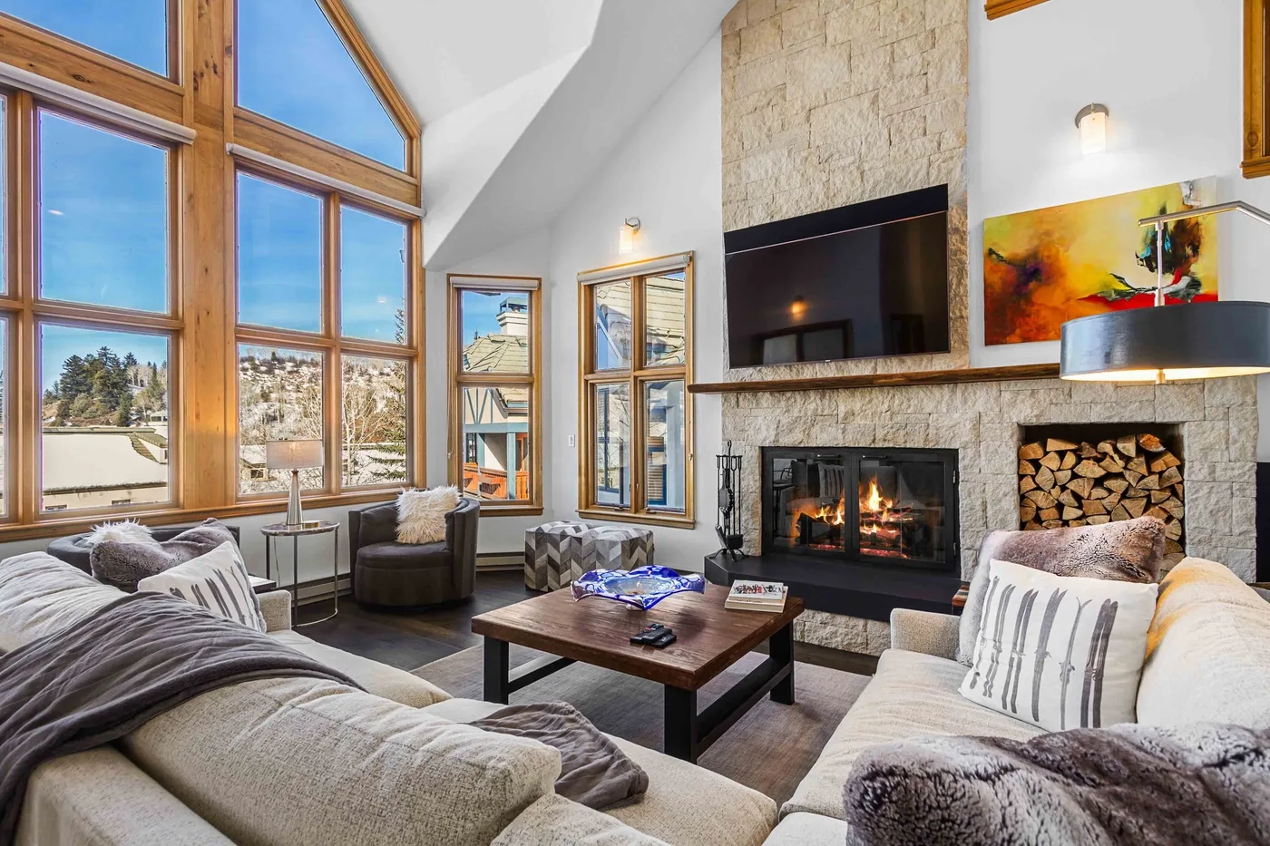 Una sala de estar con asientos, una chimenea y ventanas altas.