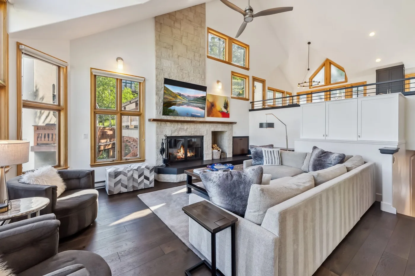 Una sala luminosa con chimenea de piedra y asientos alrededor de una mesa de centro.