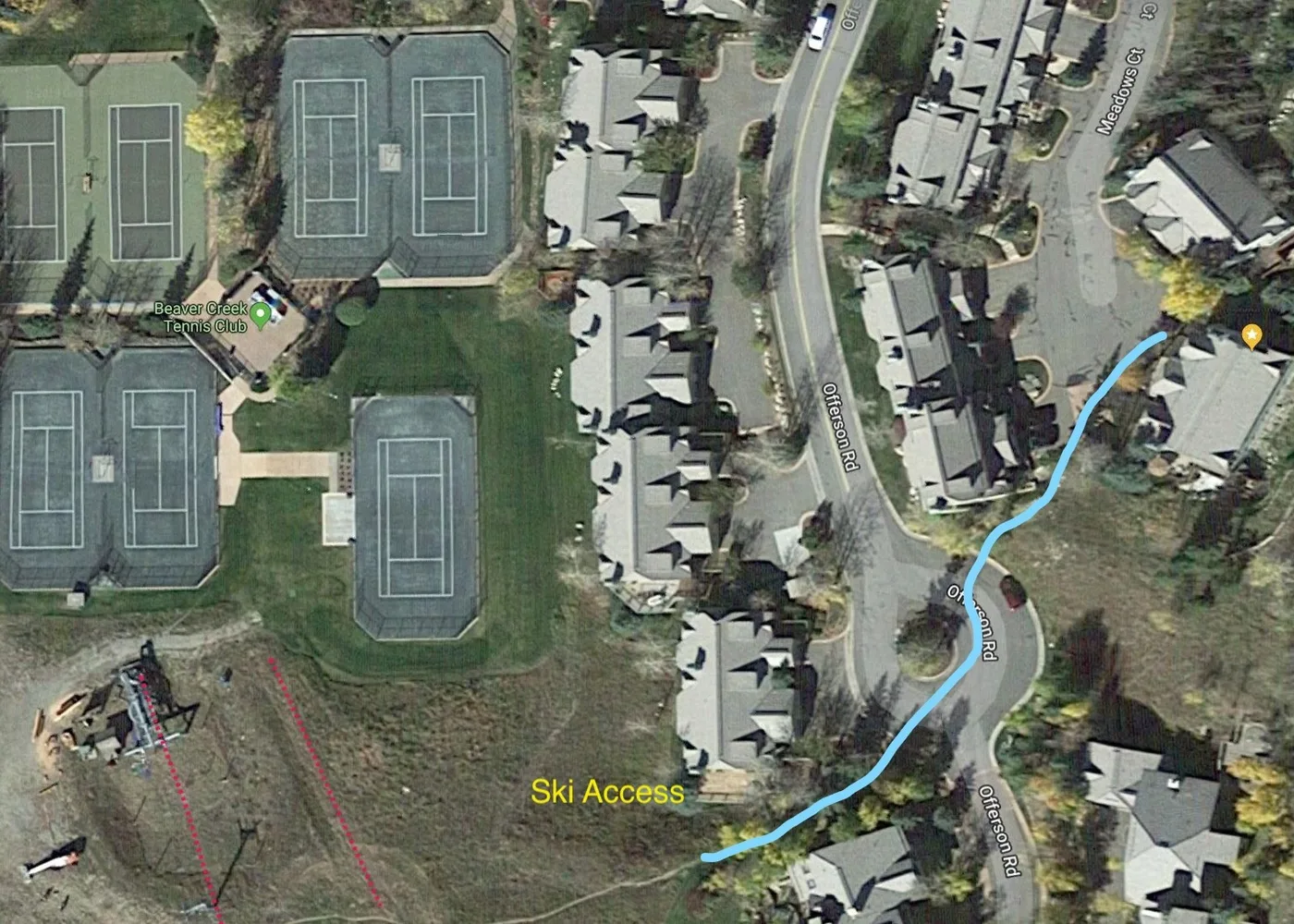 Una vista aérea muestra varias canchas de tenis, un campo de césped y casas cercanas.
