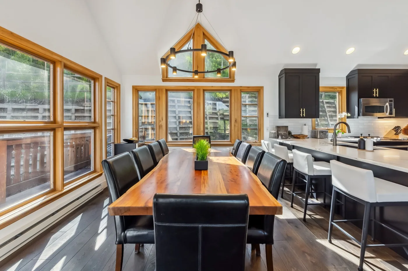 Comedor con una mesa larga de madera junto a una cocina.