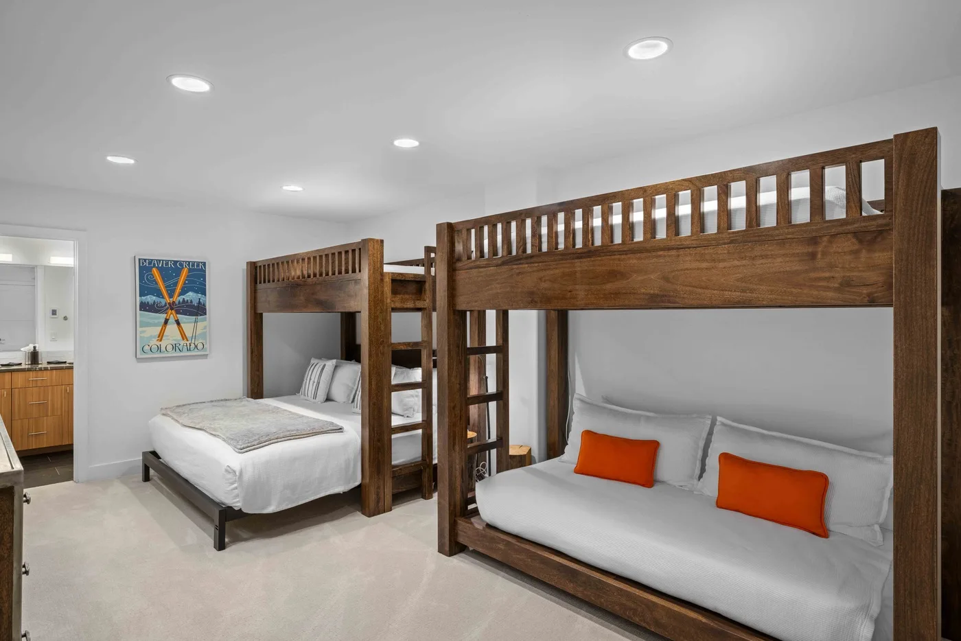 Un dormitorio con literas de madera y ropa de cama blanca.