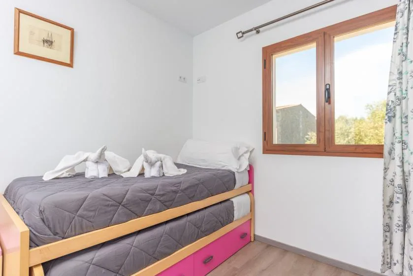 Un dormitorio con una cama individual debajo de una ventana.