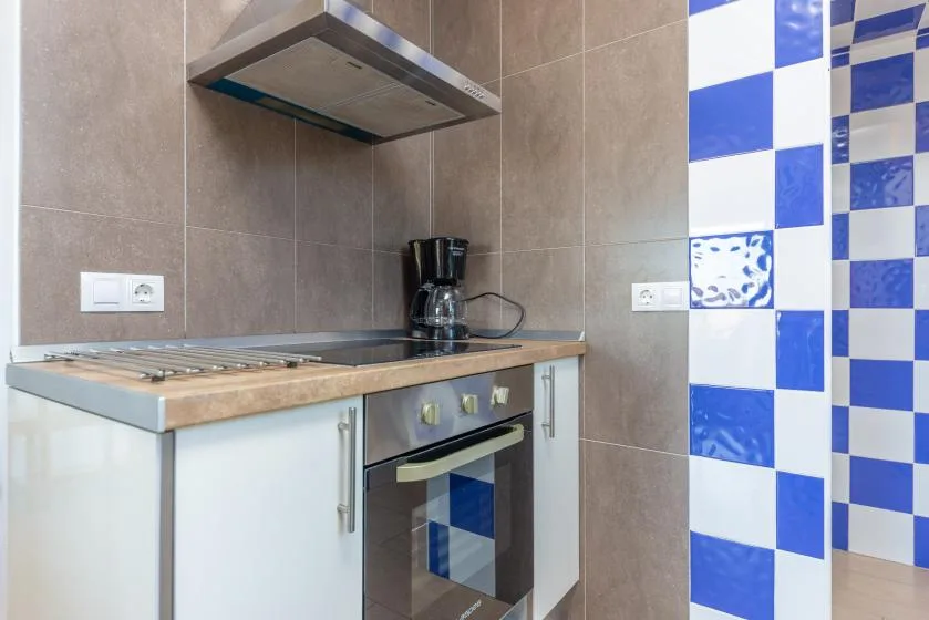 Una cocina moderna con estufa, horno y cafetera.