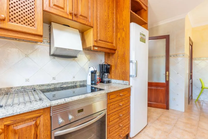 Una cocina con armarios de madera, una encimera y electrodomésticos integrados.