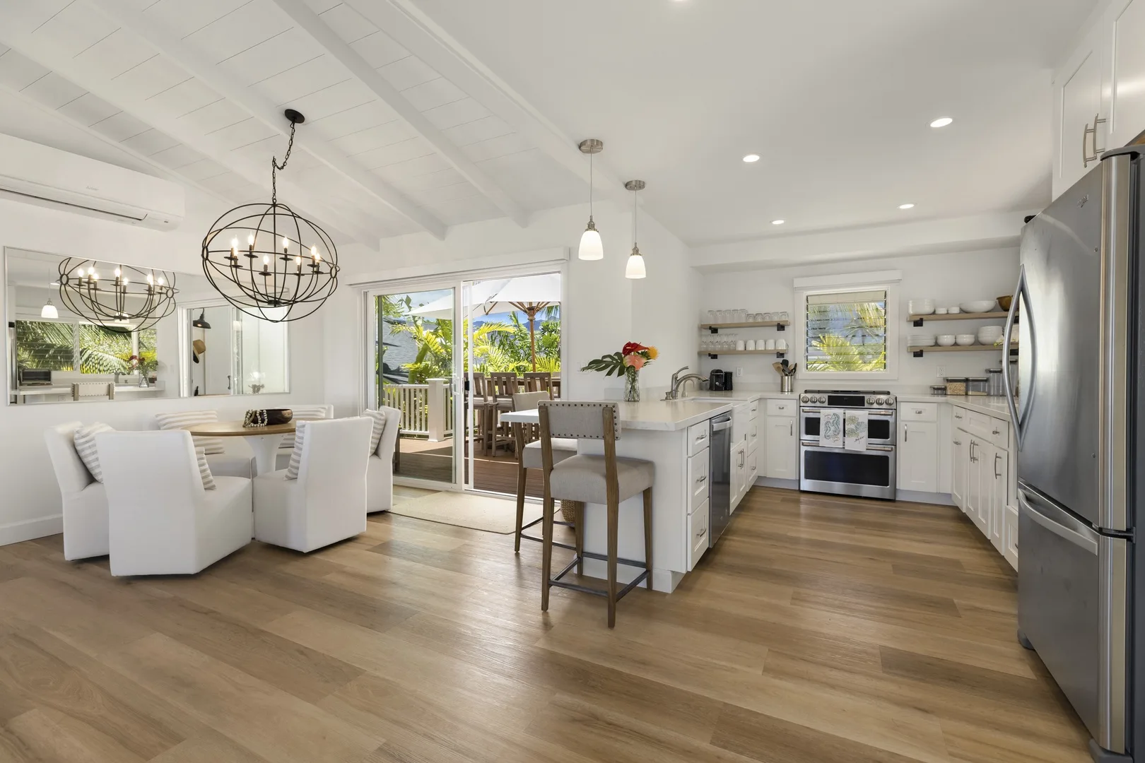 A bright open kitchen and dining area with an island and sliding glass doors.