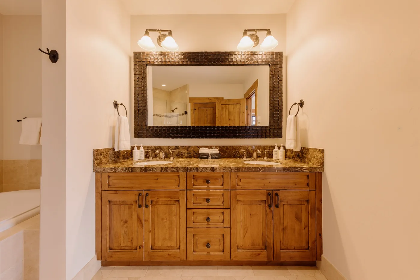 A bathroom vanity with a wide mirror and wooden cabinetry.