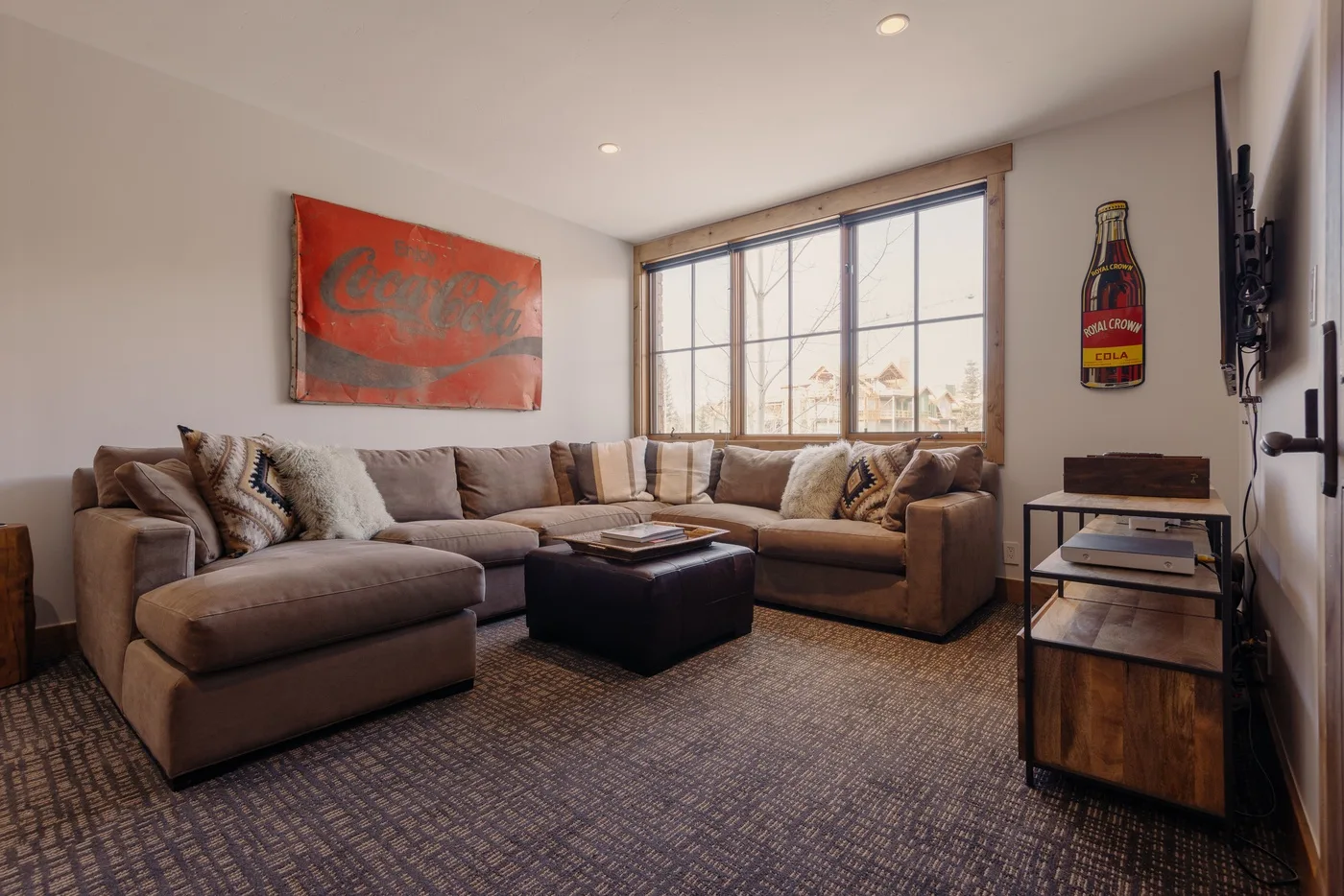 A living room with sectional seating, a coffee table, and a large window.