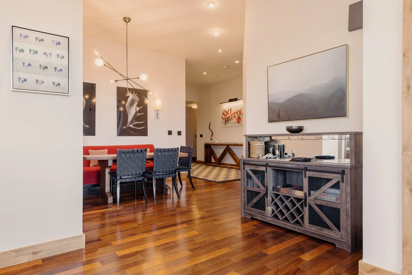 A dining area with a table and chairs beside a wooden bar cabinet.