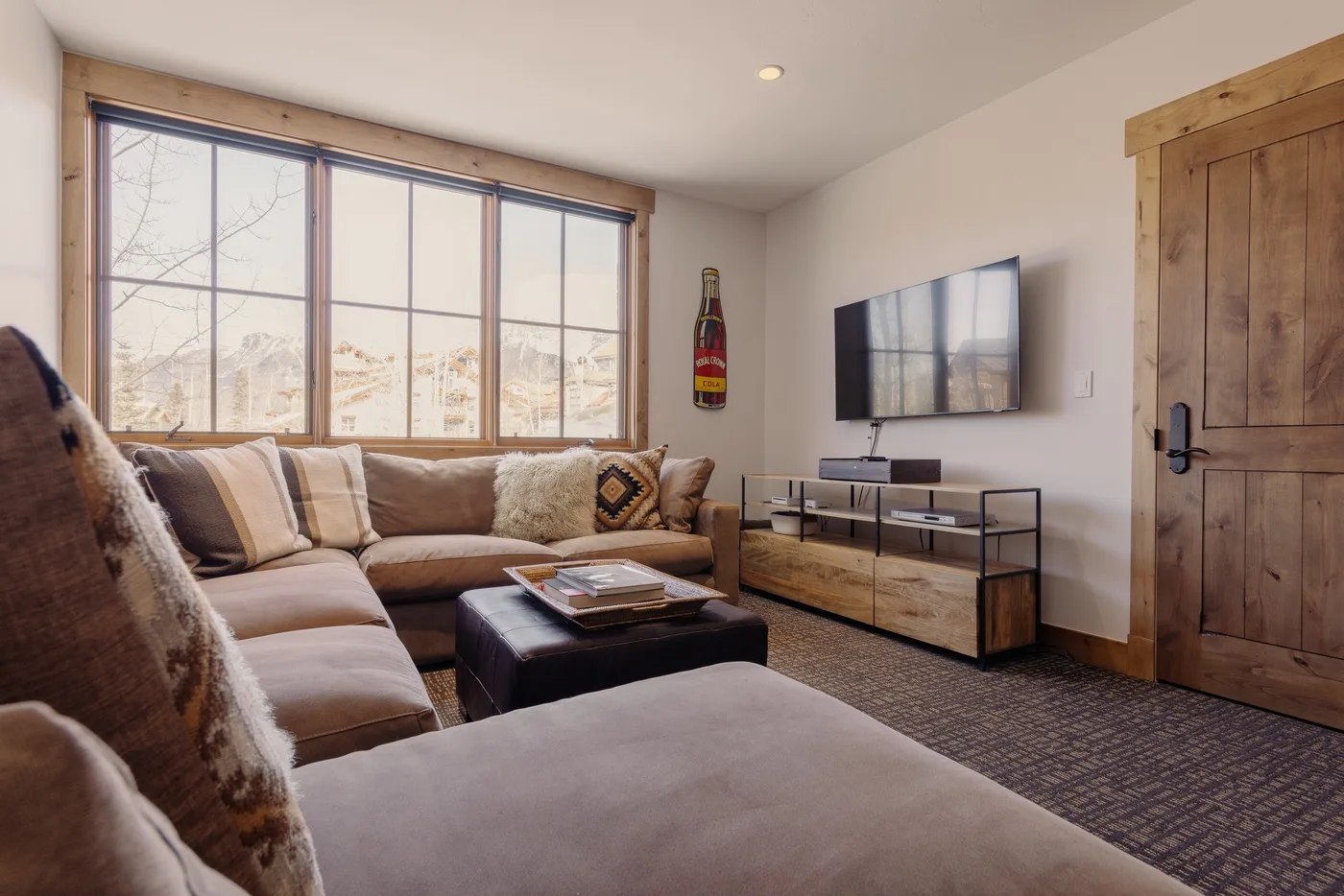 A living room with sectional seating, a coffee table, and a television.