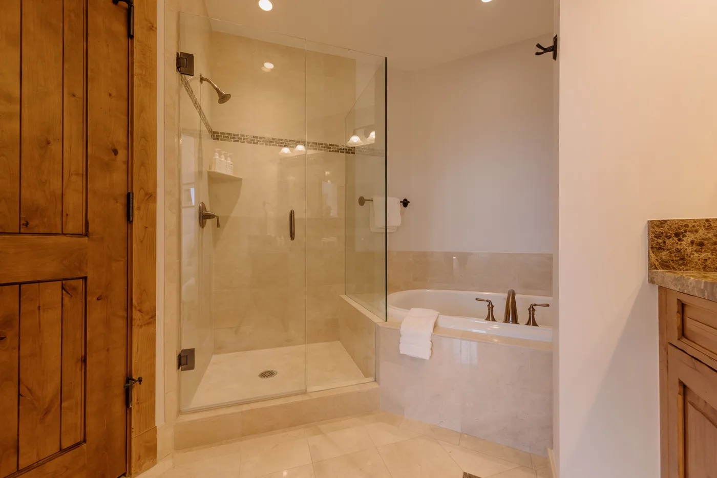 A bathroom with a glass shower beside a bathtub.