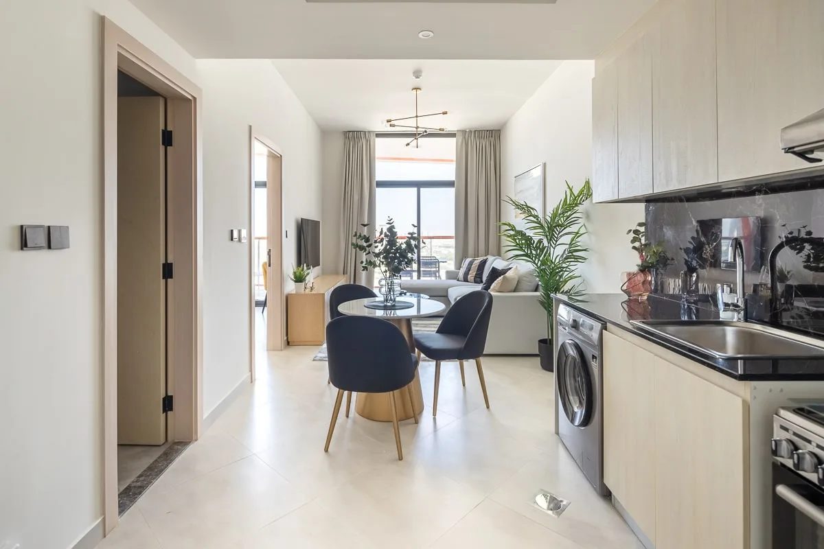 A bright open-plan living area combines a seating space and kitchen.