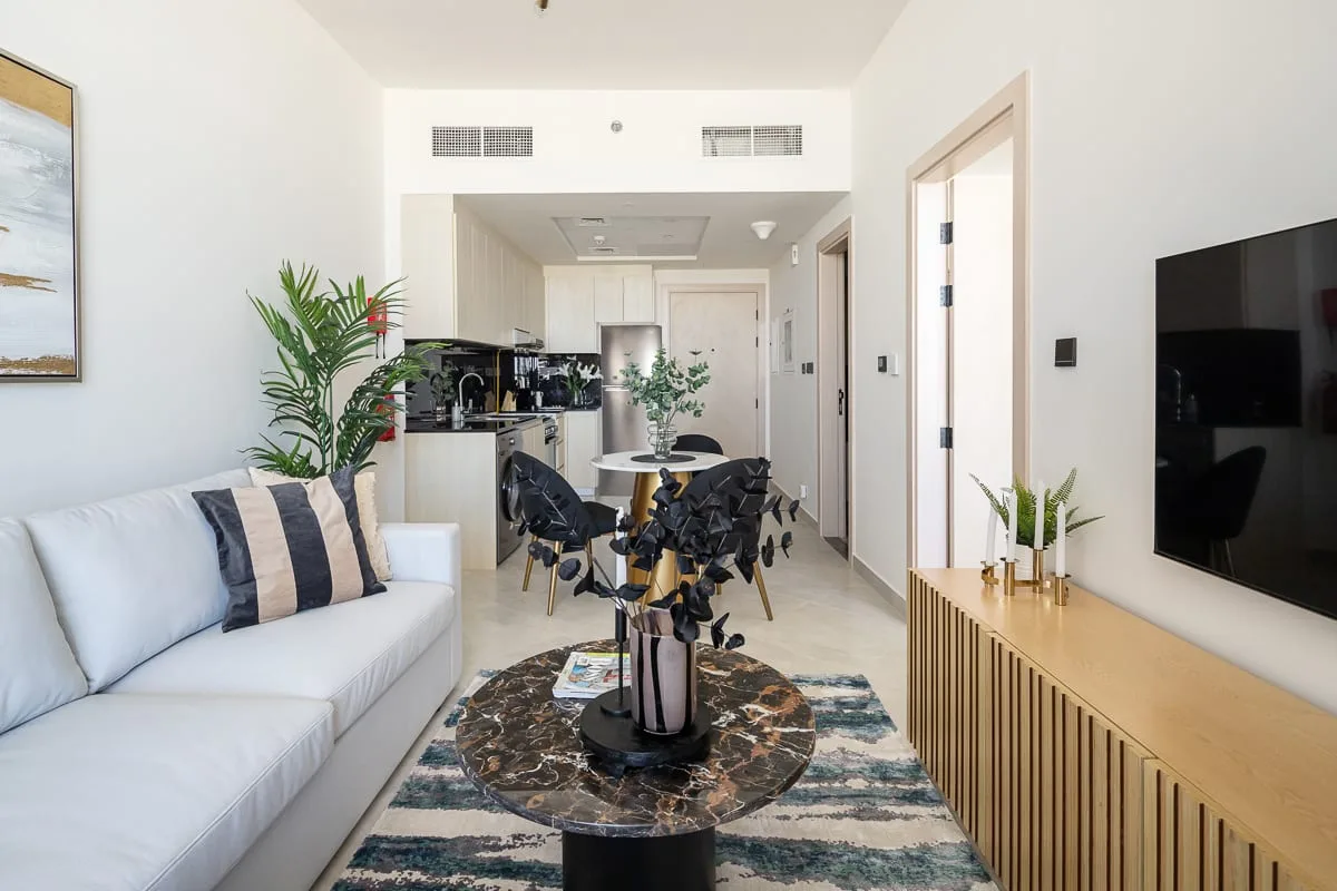 A bright open-plan living and dining area with a white sofa and dining table.