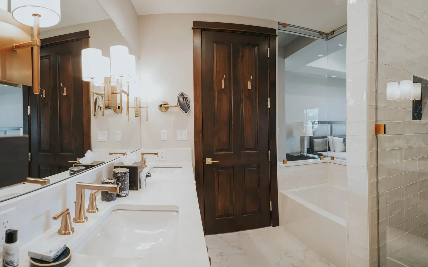 A bright bathroom with a long vanity and a bathtub beside a glass shower.