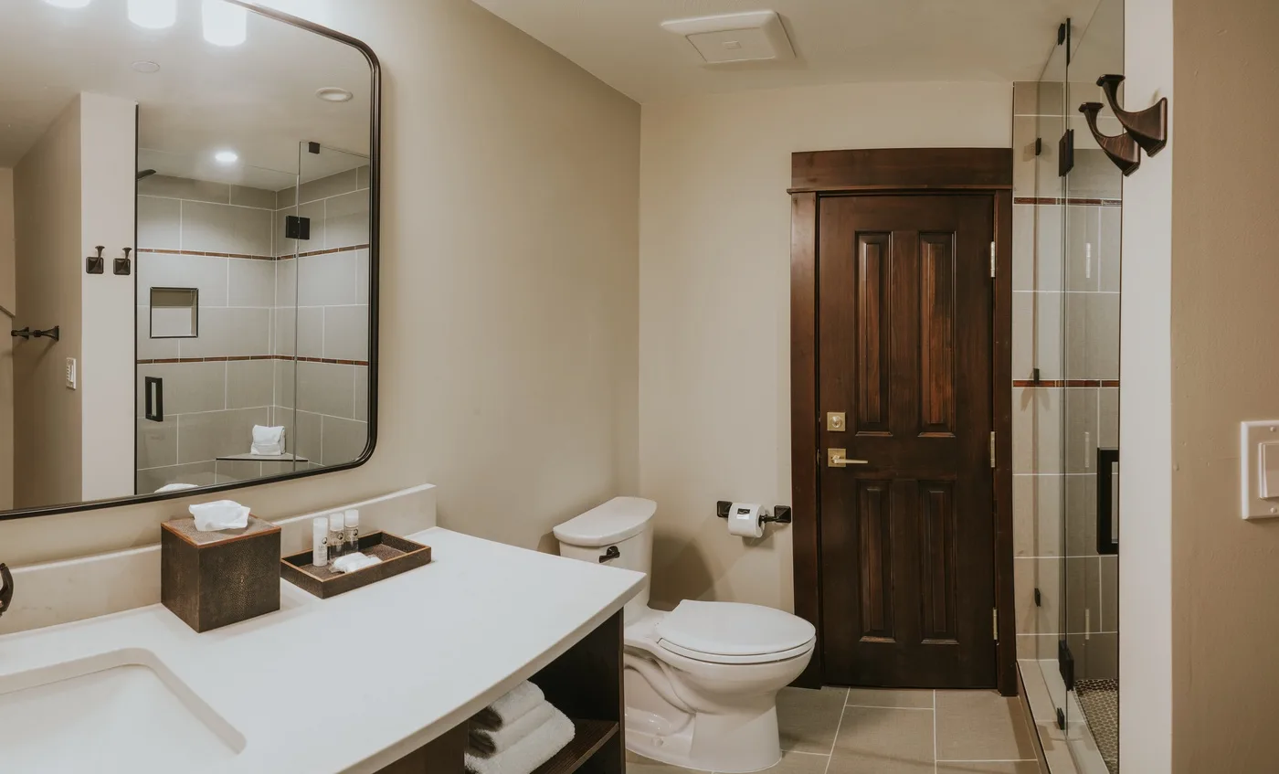 A bathroom with a wide vanity, toilet, and glass shower.