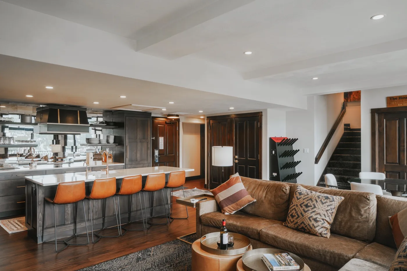 An open-plan living room and kitchen with a sofa and island seating.