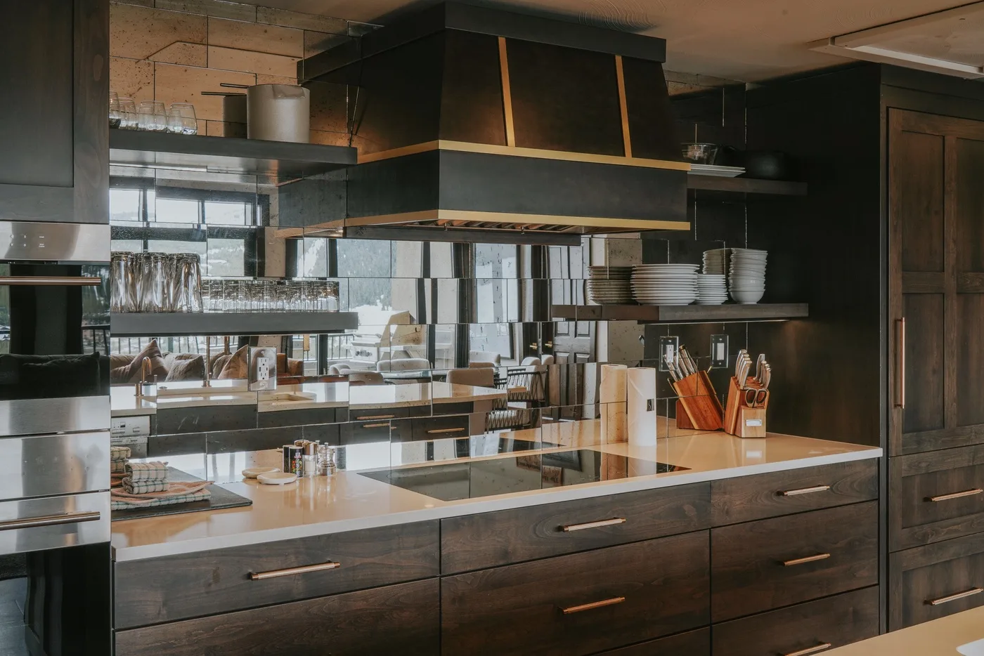 A modern kitchen with dark cabinetry, a central island, and open shelving.