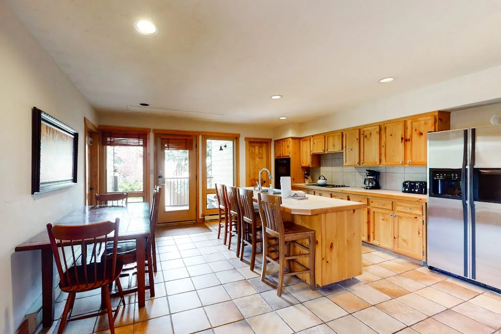 A bright kitchen and dining area with wooden cabinets and a central island.