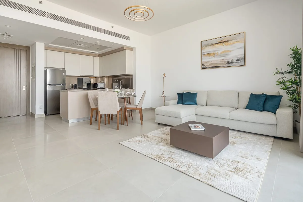 A bright living room opens onto a dining area and compact kitchen.
