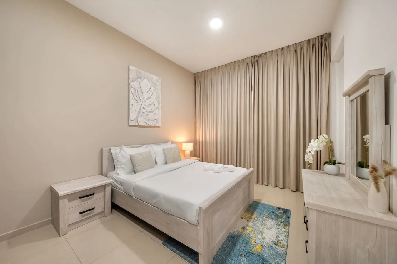 A bedroom with a neatly made bed and curtains covering the window.