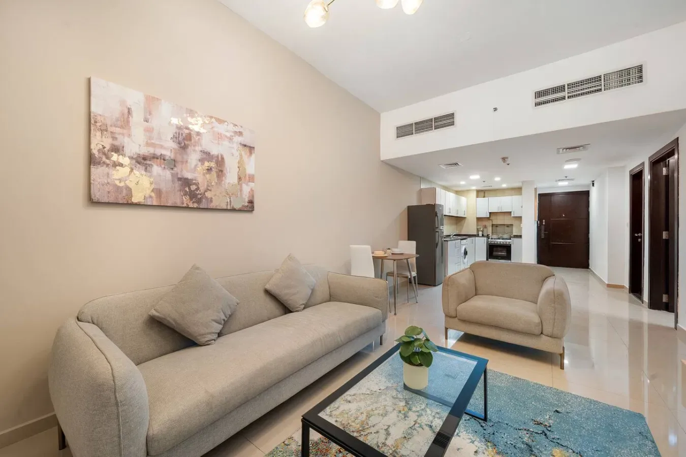 A living room with seating, a coffee table, and an open kitchen area.
