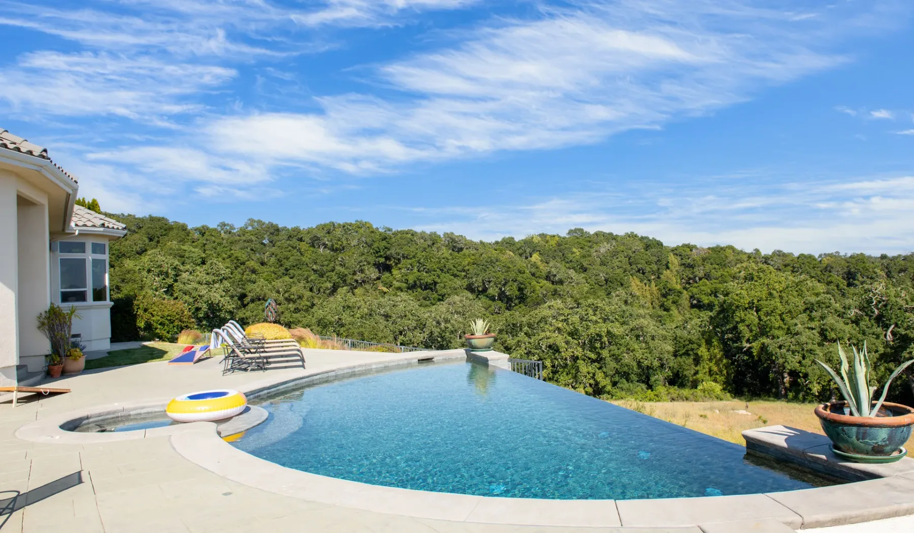 Una piscina al aire libre da a una ladera cubierta de árboles.