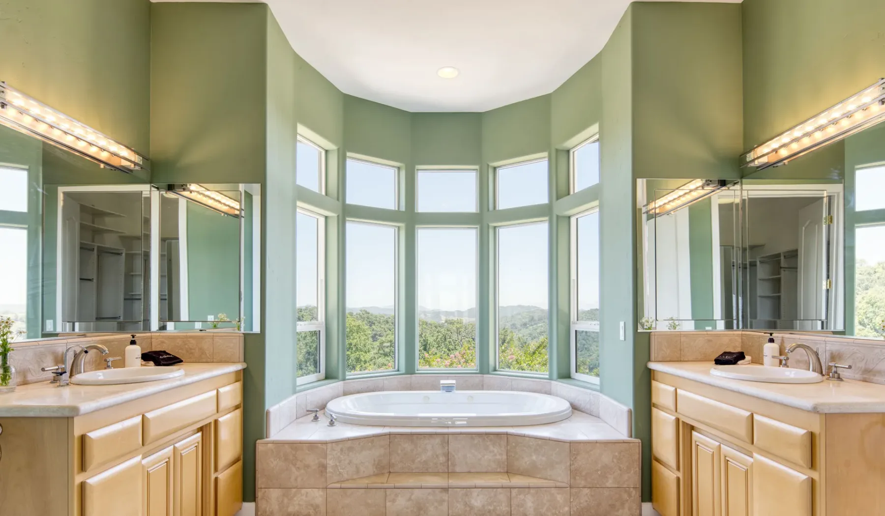 Un baño con una bañera bajo una amplia ventana mirador.