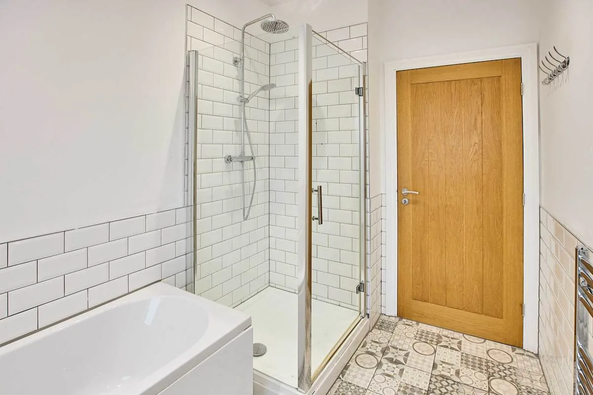 Un baño con bañera y ducha de vidrio.