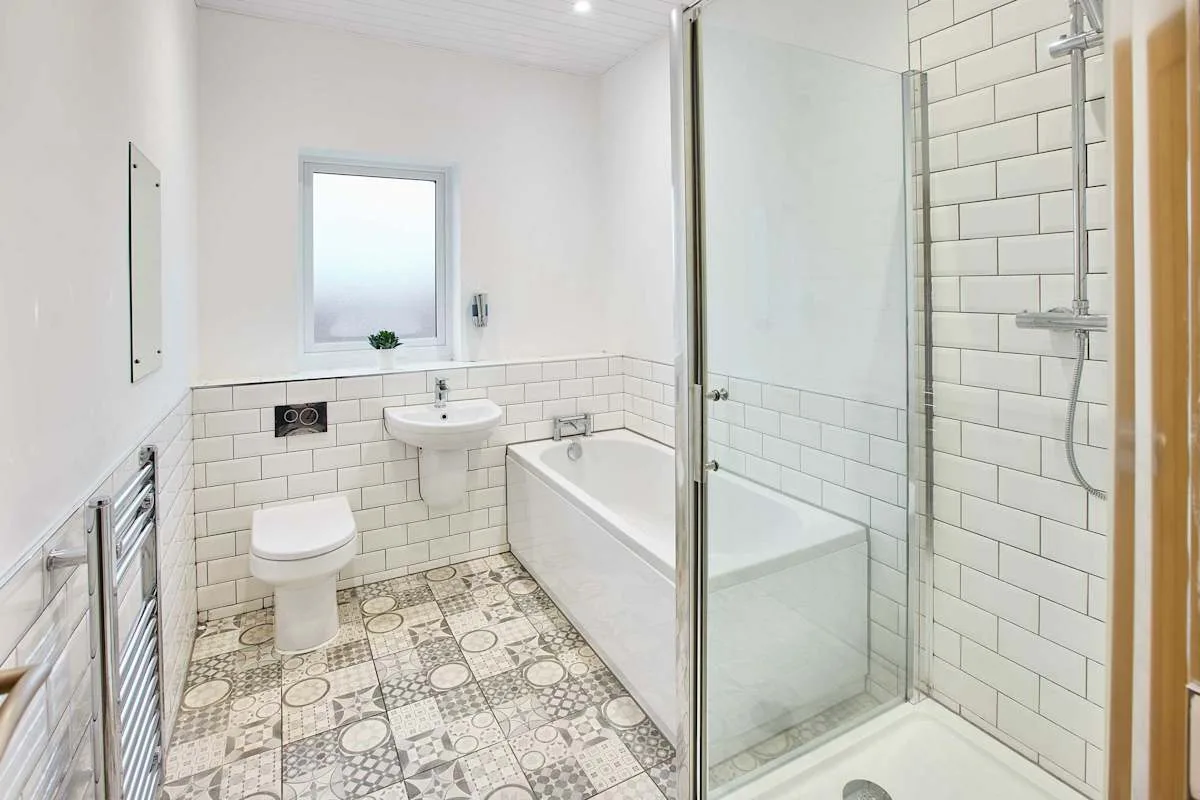Un baño luminoso con bañera, ducha, inodoro y lavabo.