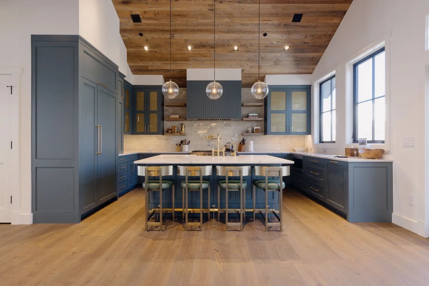 Una cocina amplia con una isla central y ventanas altas.