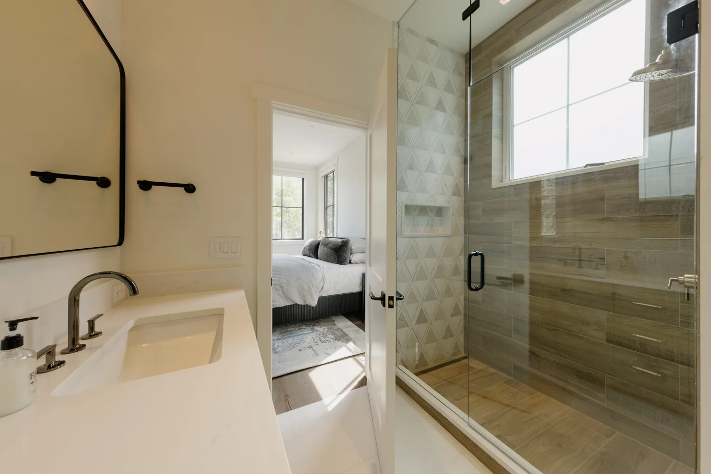 Un baño luminoso con lavabo y ducha con mampara de vidrio.