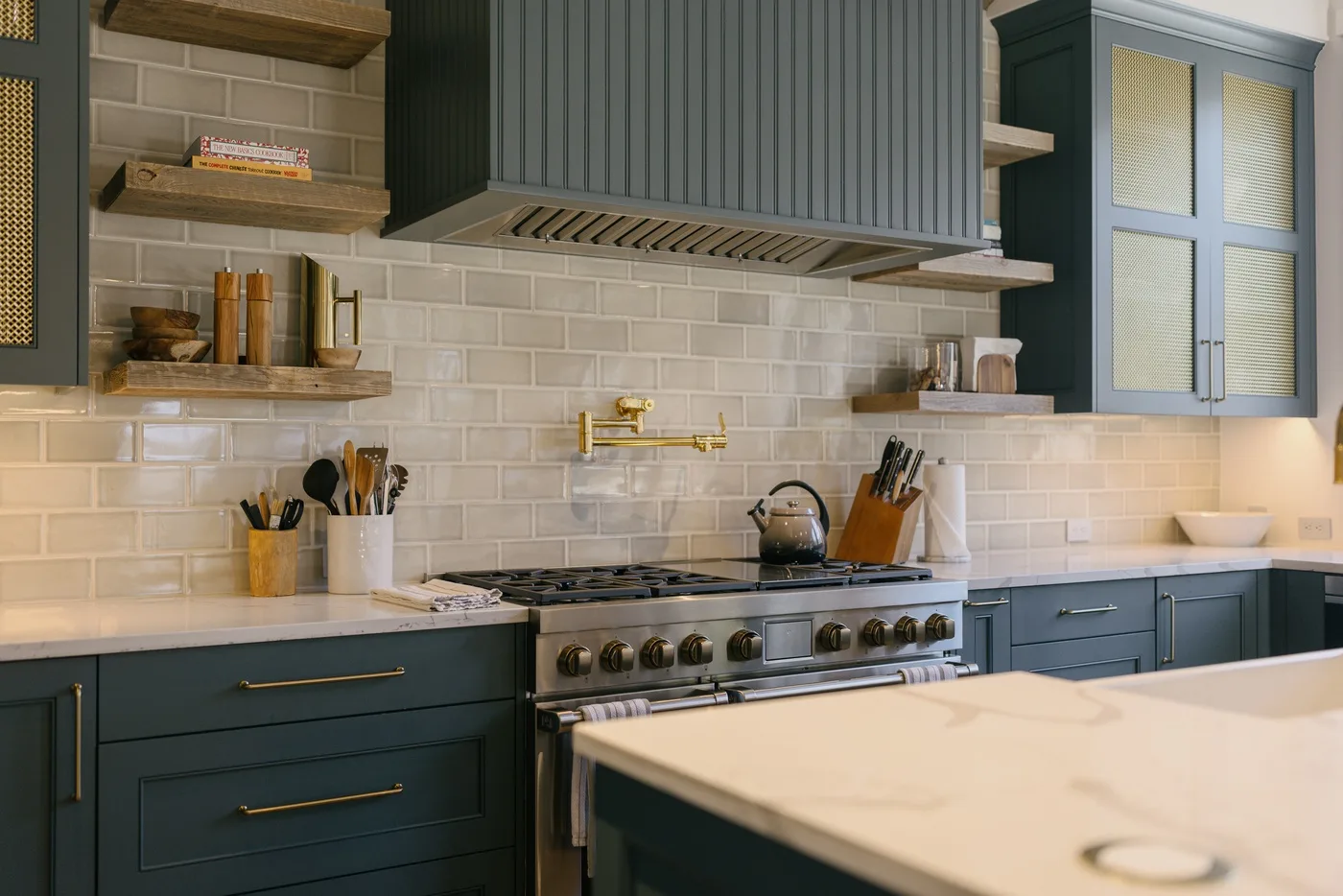 Una cocina con gabinetes oscuros, un salpicadero de azulejos y una estufa grande.