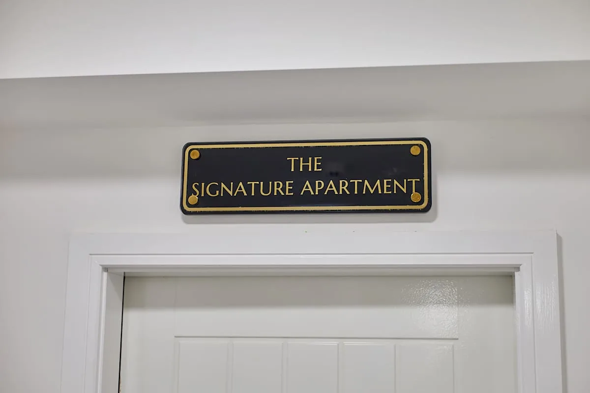 Una puerta con un letrero que dice «The Signature Apartment» encima.
