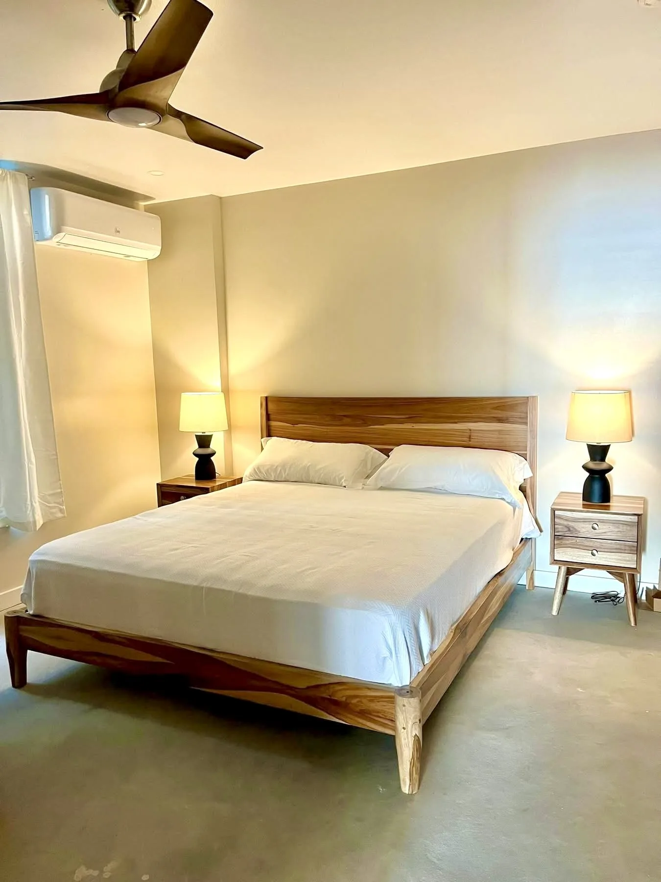 Bedroom with a wooden bed, bedside tables, and matching lamps.