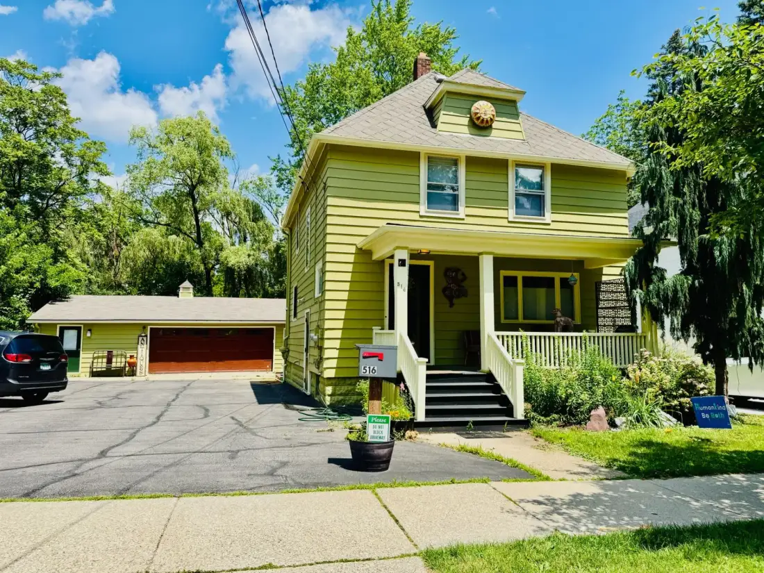A yellow house with a mailbox in front of it