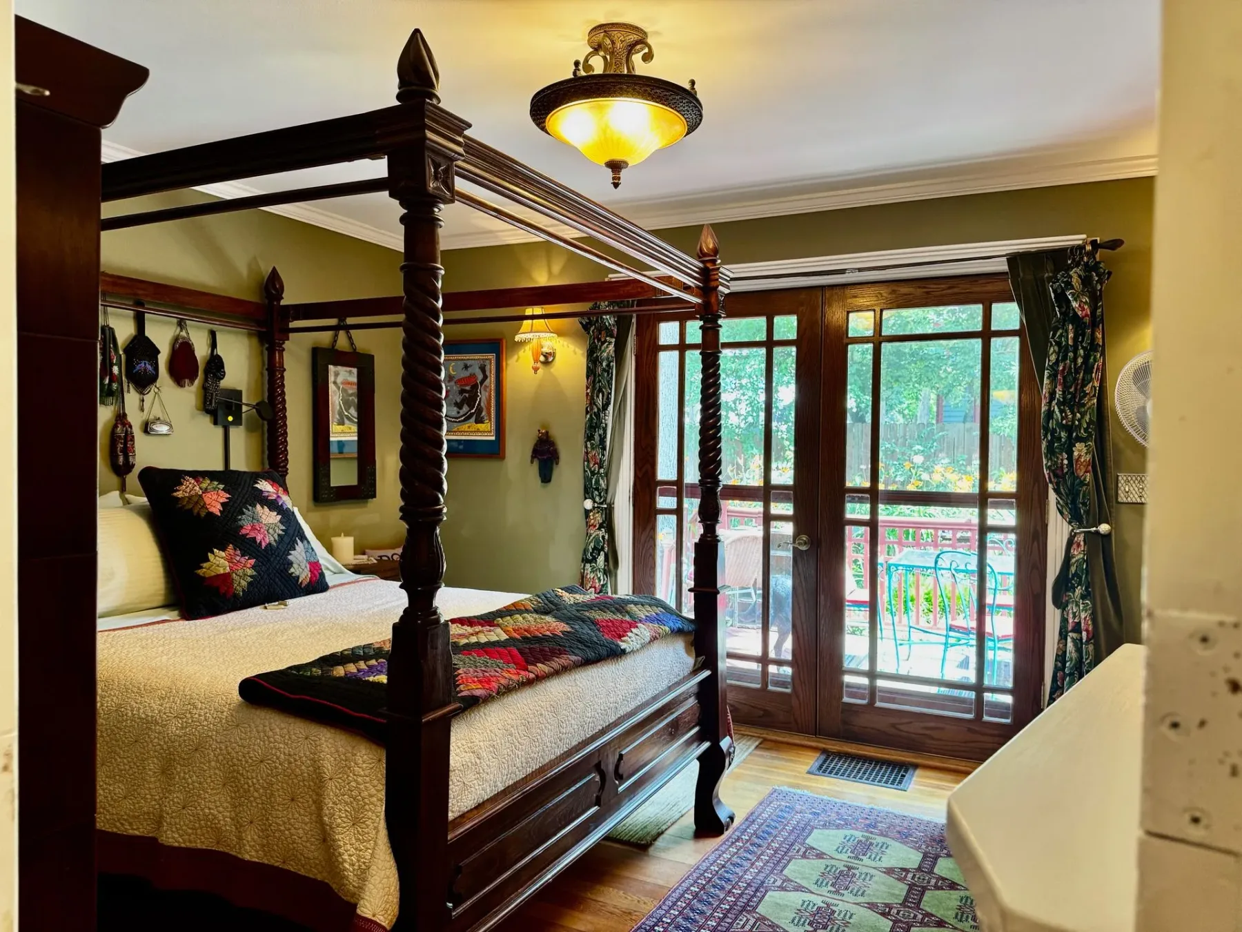 A bedroom with a four poster bed and sliding glass doors.