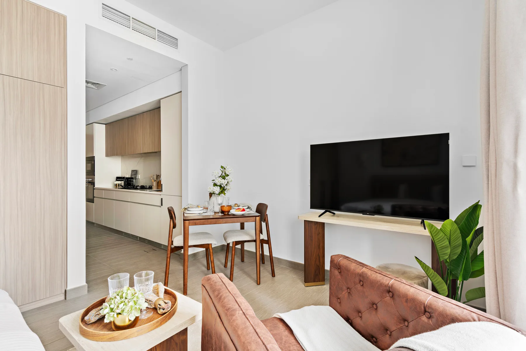 Una sala con comedor, televisión y cocina abierta.